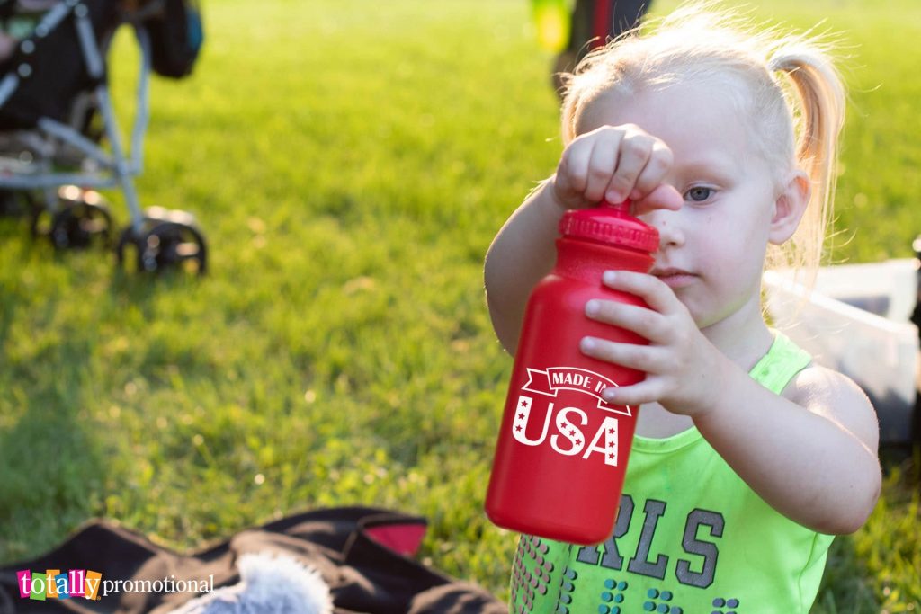 little girl holding red USA water bottle