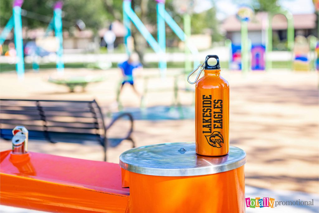 customized aluminum water bottle at a park with school logo