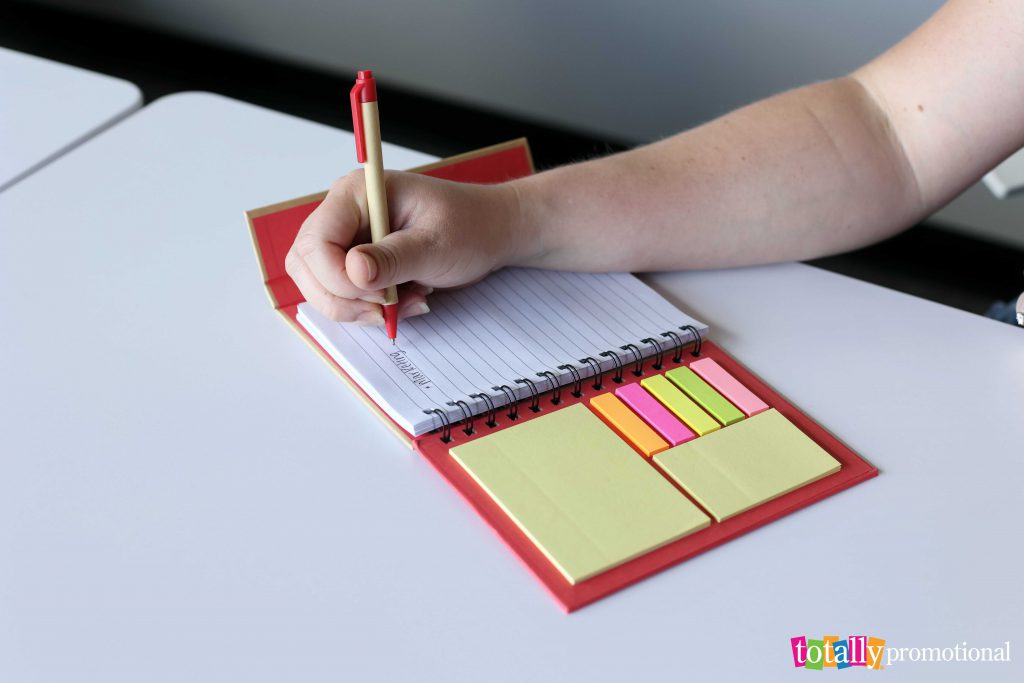 lady writing in a notebook with sticky notes