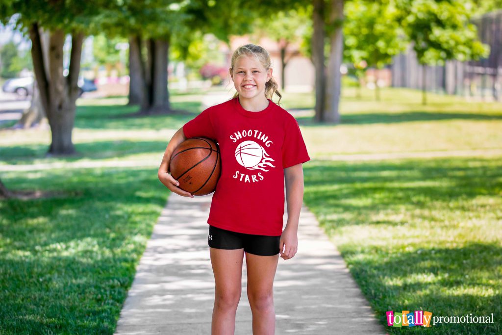 young girl holding a basketball with a custom t-shirt