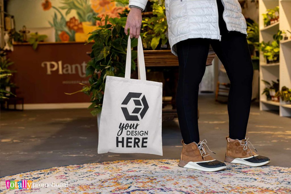 woman holding a customizable tote bag at a plant boutique