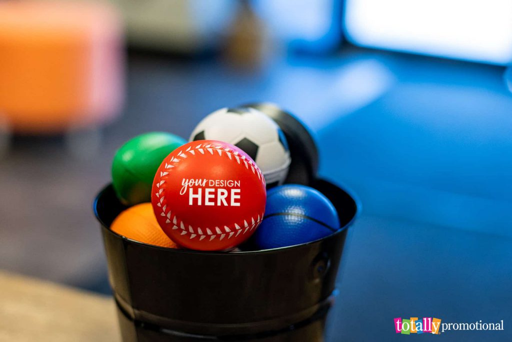 various custom sports stress balls in a bucket