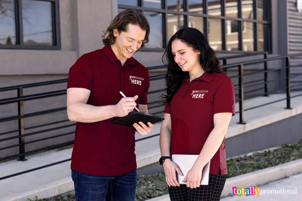 man and woman wearing customized polos for employees