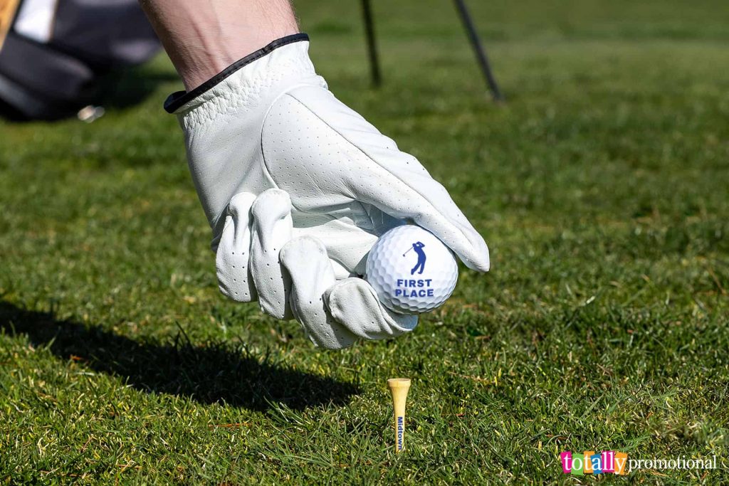 placing a customized golf ball on a customized golf tee