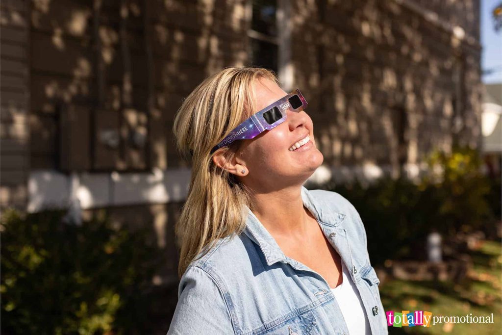 woman wearing solar eclipse glasses customized with a full color logo