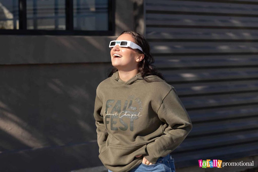 woman wearing customized solar eclipse glasses outside