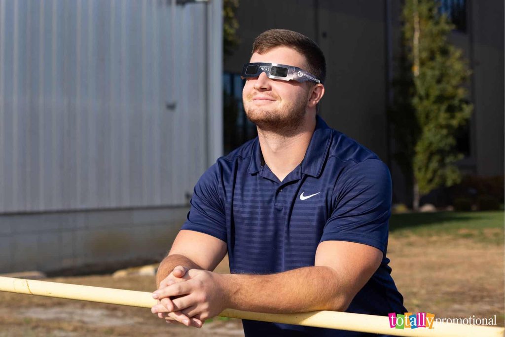 man wearing customized solar eclipse glasses outside