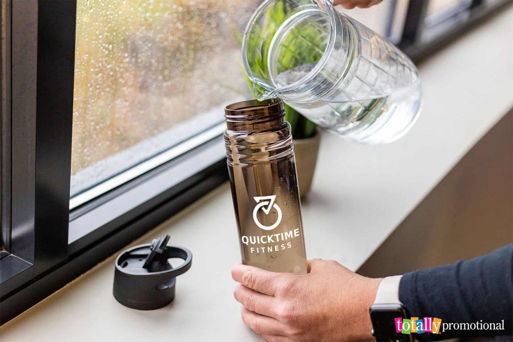 pouring water into a customizable sustainable water bottle