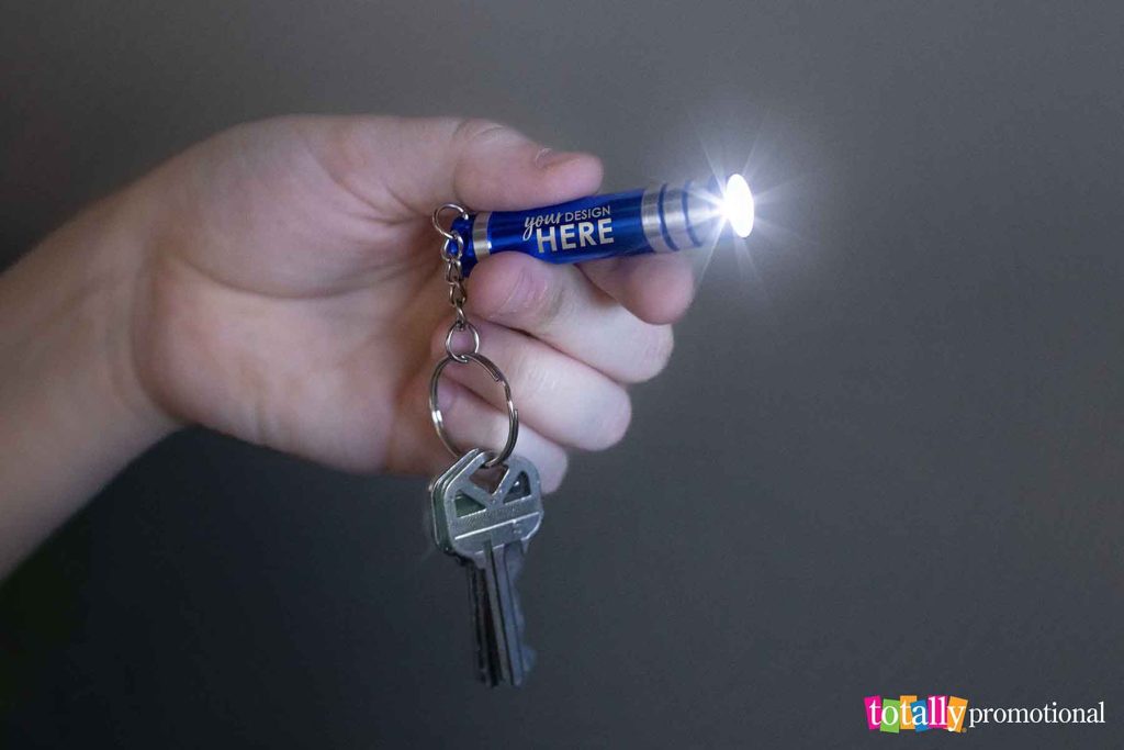 person pointing a customizable flashlight keychain